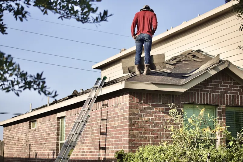 Professional roofer working on a residential roof in Davisburg